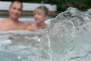 Chalet Mont Tremblant Luxury Lodge في Labelle: شخصين في حوض استحمام مع نافورة