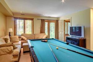 uma sala de estar com uma mesa de bilhar e uma televisão em Chalet Mont Tremblant Luxury Lodge em Labelle
