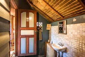 a bathroom with a sink and a door at Retro Kampot Guesthouse in Kampot