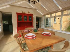 a dining room with a wooden table and chairs at Keen Cottage in Kingham