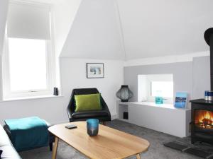 a living room with a table and a chair at The Eaves in Sandgate