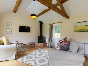 a living room with a couch and a tv at Park Bothy in Wyck Rissington