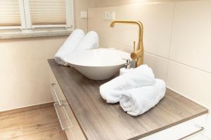 ein Badezimmer mit einem Waschbecken und Handtüchern auf der Theke in der Unterkunft Ferienwohnungen "Zur Wally" in Garmisch-Partenkirchen