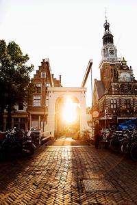 a building with the sun shining through a brick street at Kings Inn City Hotel Alkmaar in Alkmaar
