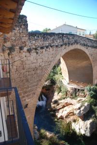 eine Steinbrücke mit einem Fluss darunter in der Unterkunft Casa La Catalina II in Beceite
