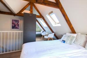 a bedroom with a white bed in a attic at Kings Inn City Hotel Alkmaar in Alkmaar