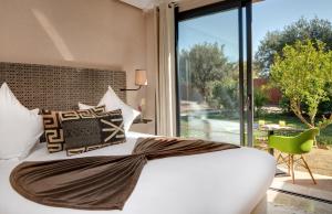 sypialnia z białym łóżkiem i dużym oknem w obiekcie Oasis lodges w Marakeszu