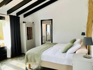a white bedroom with a bed and a window at Finca Bona Nit in Jávea