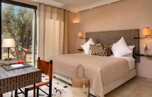 a bedroom with a bed and a large window at Oasis lodges in Marrakech