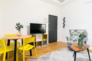 a living room with a table and yellow chairs at CATCHY DREAMS Spacious & Homey Apartment in Bucharest