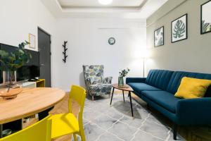 a living room with a blue couch and a table at CATCHY DREAMS Spacious & Homey Apartment in Bucharest