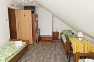 a attic room with two beds and a closet at Penzion pod svahem in Železná Ruda