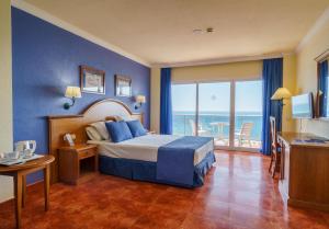 a bedroom with a bed with a view of the ocean at Hotel Isabel in Torremolinos