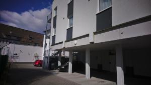 a white building with a red car parked next to it at Hotel Schillerquartier in Kassel