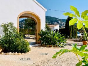 a house with an archway and plants in a yard at Finca Bona Nit in Jávea