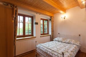 1 dormitorio con 1 cama en una habitación con ventanas en Apartamenty Batur, en Karpacz