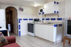 a kitchen with white cabinets and blue and white tiles at Havasu Inn & Suites in Lake Havasu City