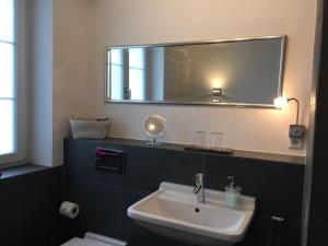 ein Badezimmer mit Waschbecken und Spiegel in der Unterkunft Gästehaus am Weiher in Weil am Rhein