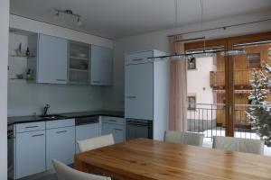 a kitchen with a wooden table and a dining room at Chasa Azura in Scuol