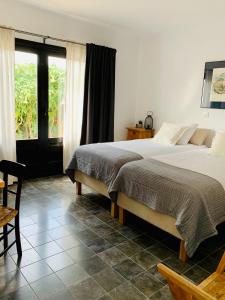 a bedroom with two beds and a table and a window at Finca Bona Nit in Jávea