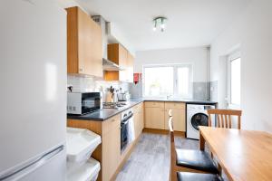 a kitchen with wooden cabinets and a wooden table at The Place to Yourself - Swansea City in Swansea