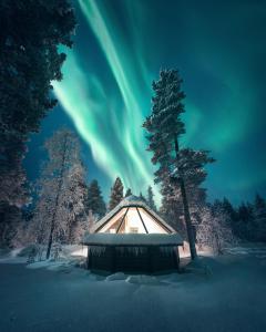 an igloo in the snow with the aurora in the sky at Aurora Village Ivalo in Ivalo
