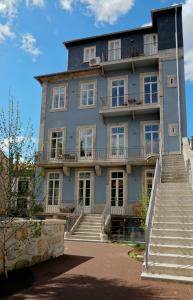 Un grand bâtiment bleu avec des escaliers se trouve juste devant. dans l'établissement Aparthotel Oporto Palace, à Porto