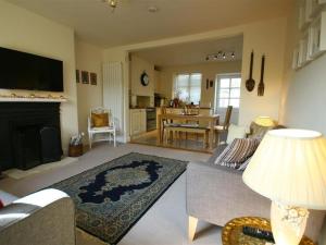 a living room with a couch and a fireplace at Honeysuckle Cottage in Stow on the Wold