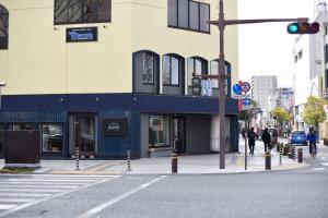 een gebouw in een stadsstraat met een verkeerslicht bij Guesthouse & Lounge FARO in Iwaki