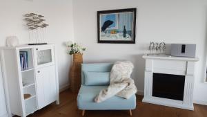 a living room with a blue chair and a fireplace at Loft 5 - Urlaub direkt an der Förde in Flensburg