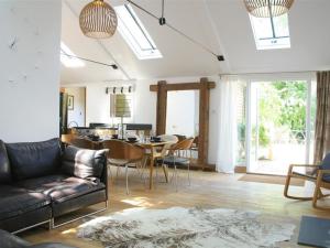 a living room with a couch and a table with chairs at The Linhay in Faringdon