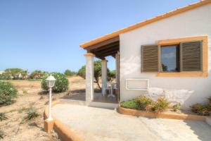 a house with a porch and a table outside at Hotel Club Sunway Punta Prima in Es Pujols