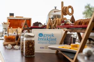 einen Tisch mit einem Schild, das Lebensmittelfrühstück mit Essen liest in der Unterkunft Aeolos Beach Resort in Gastouri