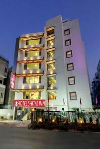 een hoog gebouw met een bord ervoor bij HOTEL SHITAL INN in Ahmedabad