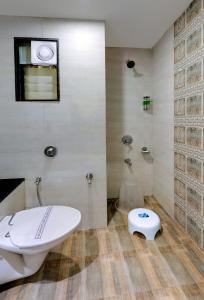 a bathroom with a tub and a toilet and a sink at HOTEL SHITAL INN in Ahmedabad