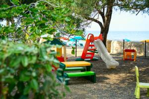 un parco giochi con giochi colorati e la spiaggia di Testa di Monaco Natural Beach a Capo dʼOrlando