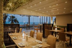 un restaurante con mesas y sillas y vistas al océano en Hotel Meridional, en Guardamar del Segura