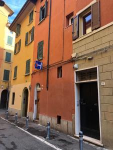 an orange building with a black door on a street at Realkasa Senzanome Flat in Bologna