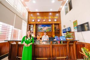 a woman in a green dress standing in front of a bar at Hoang Duc Hotel in Chau Doc