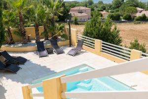 a patio with chairs and a swimming pool at Villa Vaunage Piscine Chauffée in Langlade