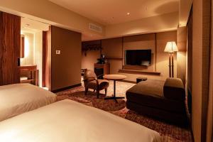 a hotel room with two beds and a television at THE BASICS FUKUOKA in Fukuoka
