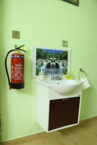 a bathroom with a sink and a fire hydrant at Hotel NKC Airport in Chennai