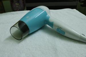 a blue and white hair dryer sitting on a towel at Hotel NKC Airport in Chennai