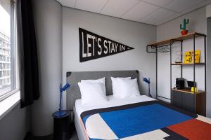 Un dormitorio con una cama con un cartel que dice que nos quedemos en The Social Hub Amsterdam West 4 star, en Ámsterdam
