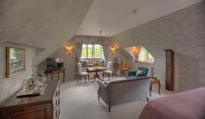 a living room with a bed and a dining room at Gravetye Manor in East Grinstead