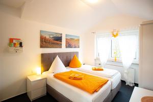 een slaapkamer met een bed met een oranje deken bij Hotel Emmerich in Winningen