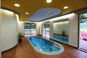 - une grande piscine dans une pièce dotée de fenêtres dans l'établissement Le Clos Champel Hôtel Restaurant Logis, à Cesson-Sévigné