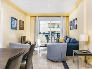ein Wohnzimmer mit einem blauen Sofa und einem Tisch in der Unterkunft Apartamento 357 in Marbella