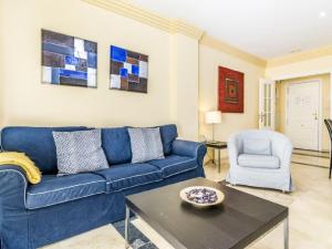 eine blaue Couch und ein Stuhl im Wohnzimmer in der Unterkunft Apartamento 357 in Marbella