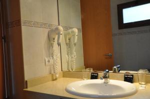 a bathroom with a sink and a mirror at Hotel Club Sunway Punta Prima in Es Pujols